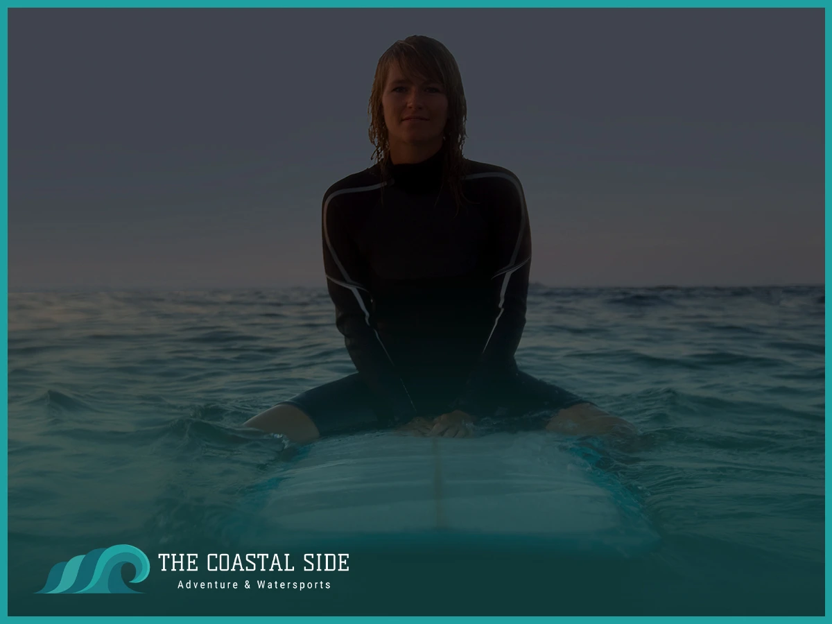 Woman in a wetsuit surfing at night