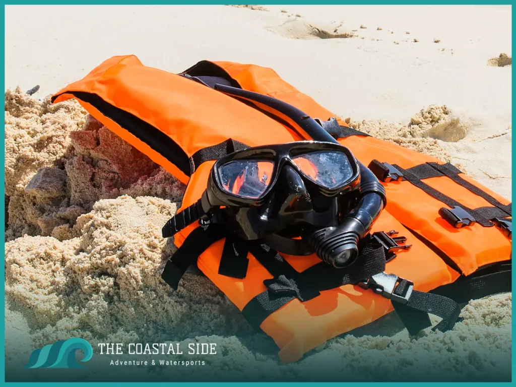 Life jacket and goggles on the sand