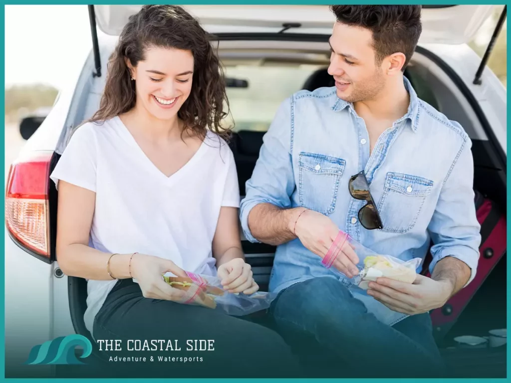 Man and woman eating snacks in the back of a car