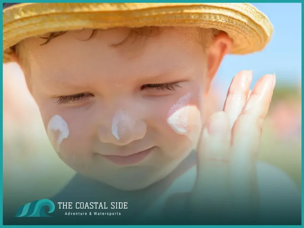 Little boy with sunscreen on his face wearing a straw hat