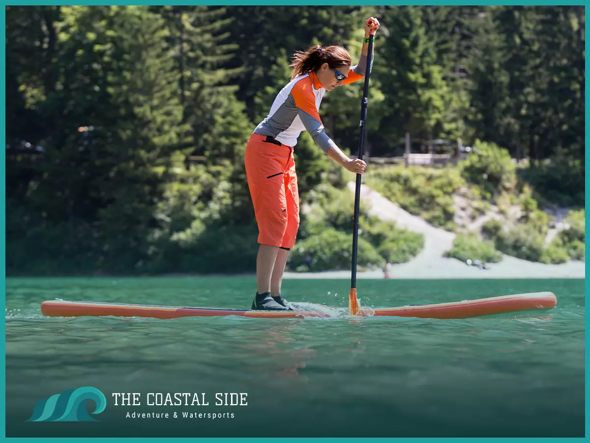 a woman paddle boarding while wearing water shoes