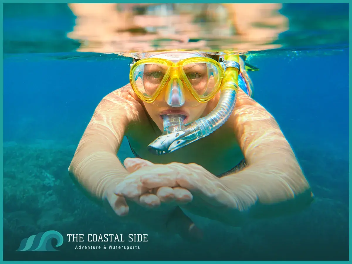 Young person snorkeling with a yellow snorkel mask