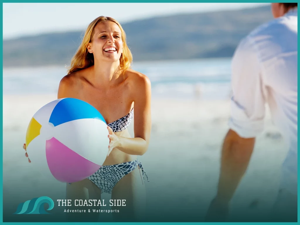 Woman playing with a beach ball on shore