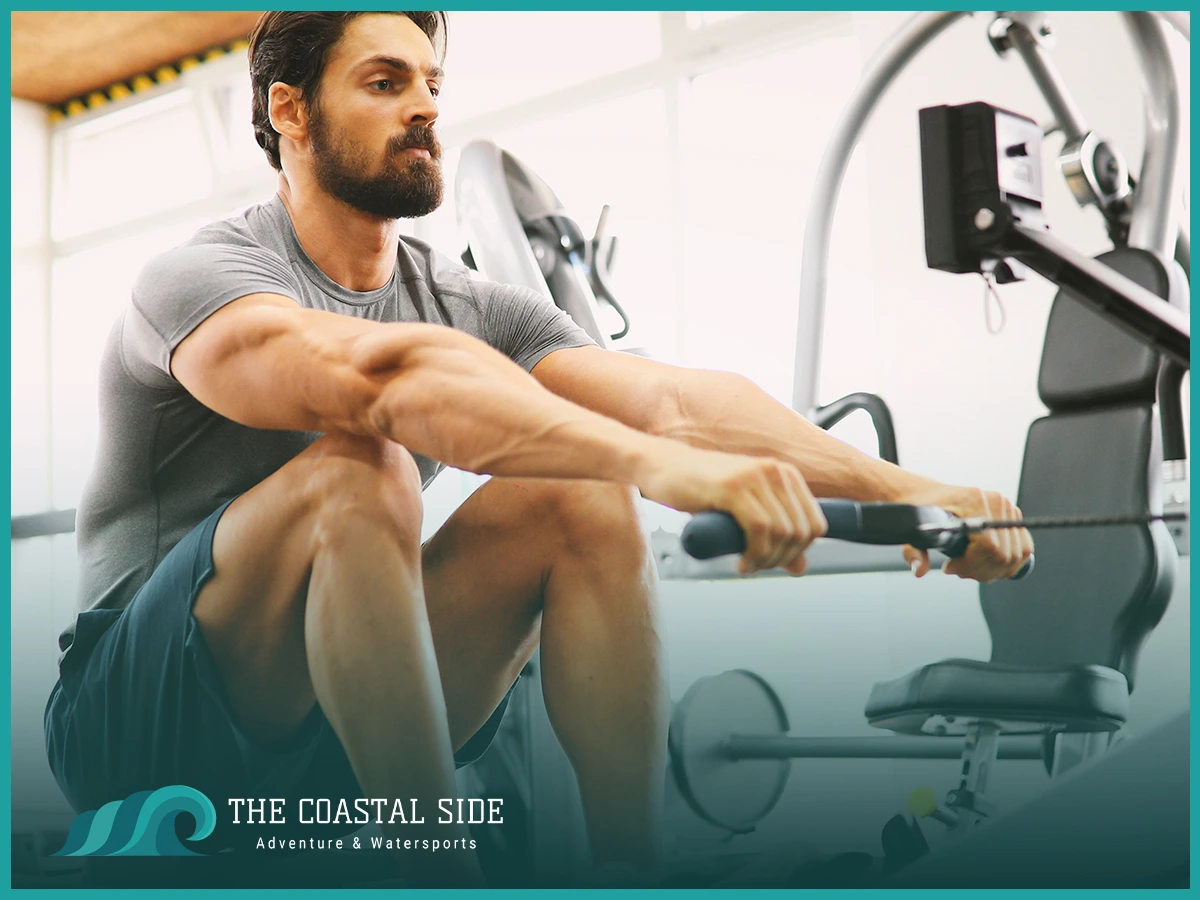 A man using a rowing machine to prepare for paddle boarding