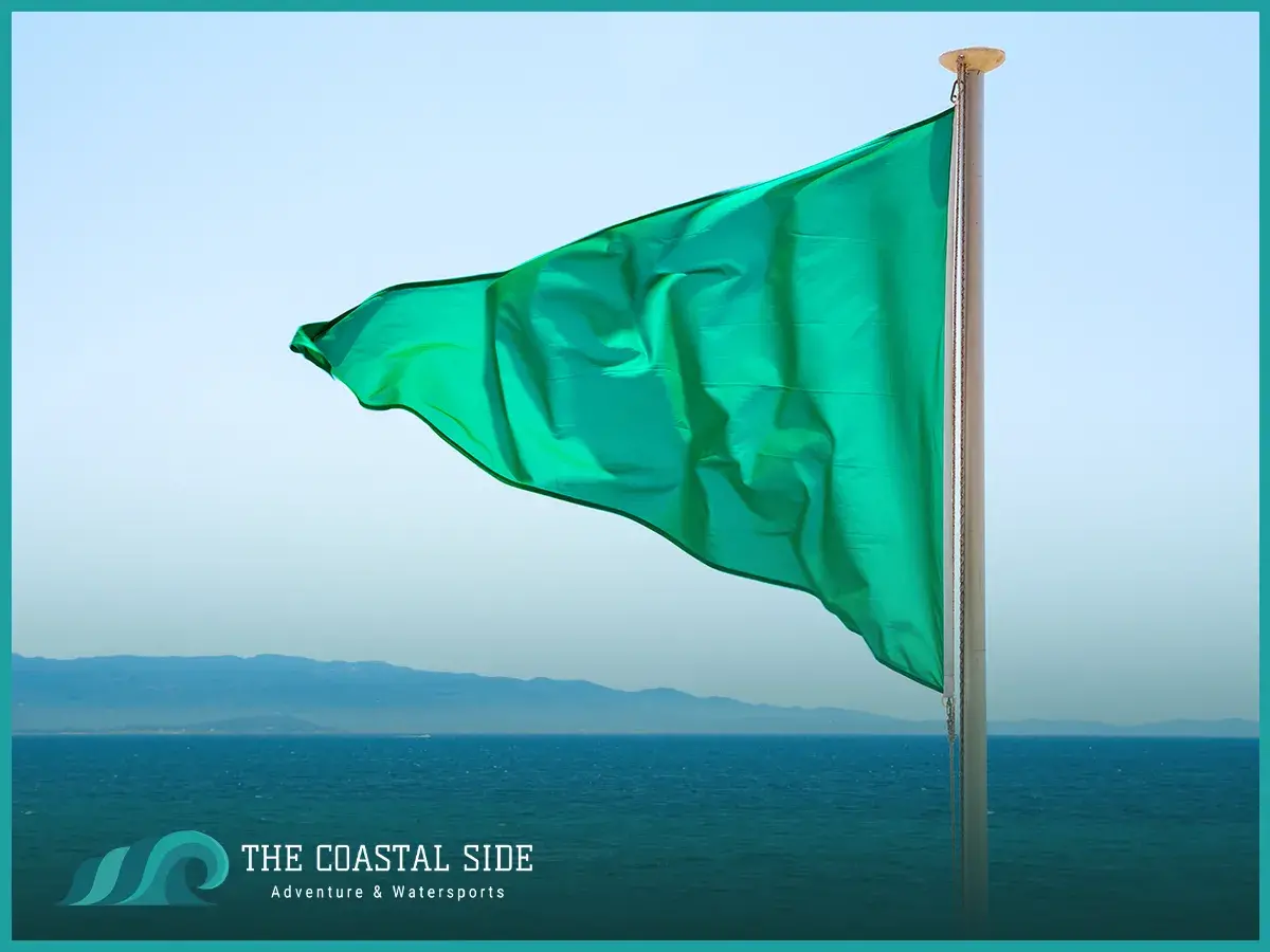 Green flag flying in the wind at the ocean