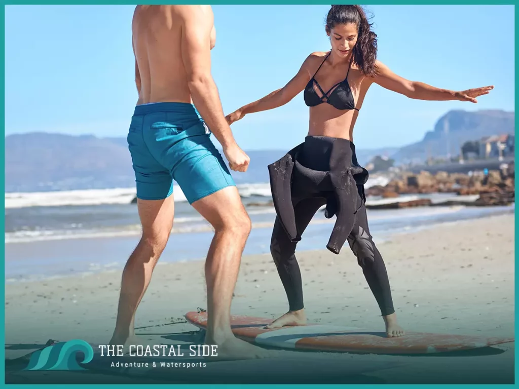 Woman practicing how to surf on the sand