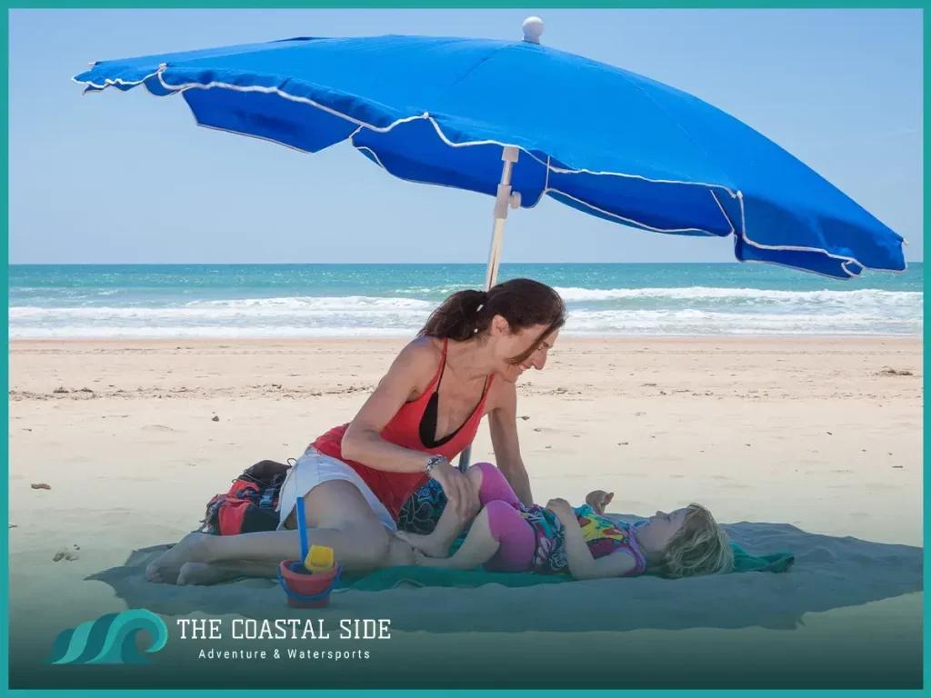 Mother and child under a blue beach umbrella