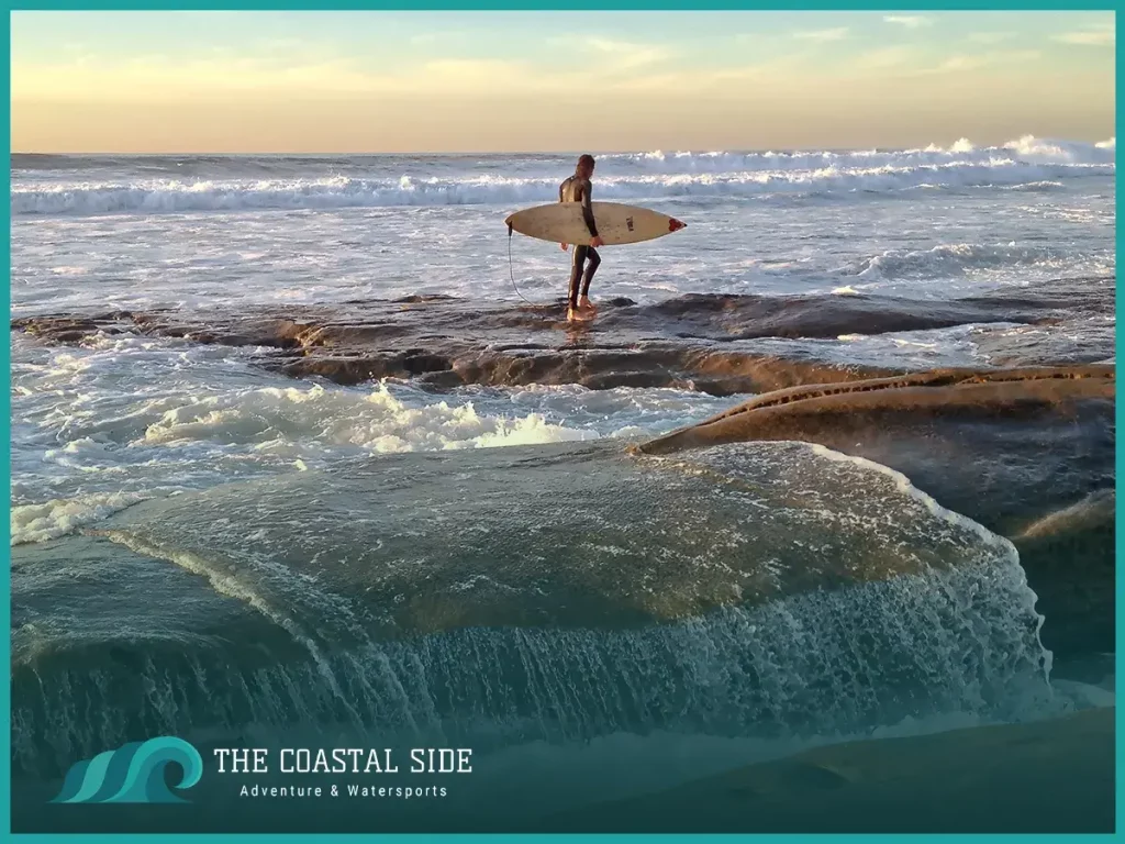 Surfer watching the low tide on the shore