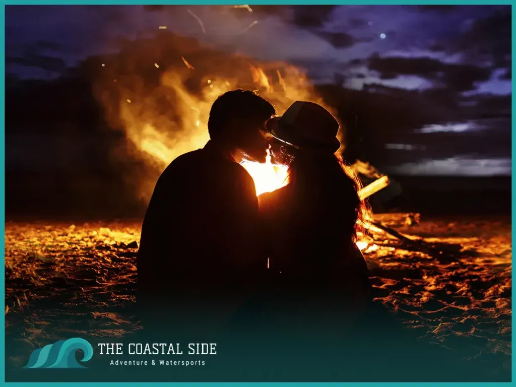 A couple kissing on the beach at night
