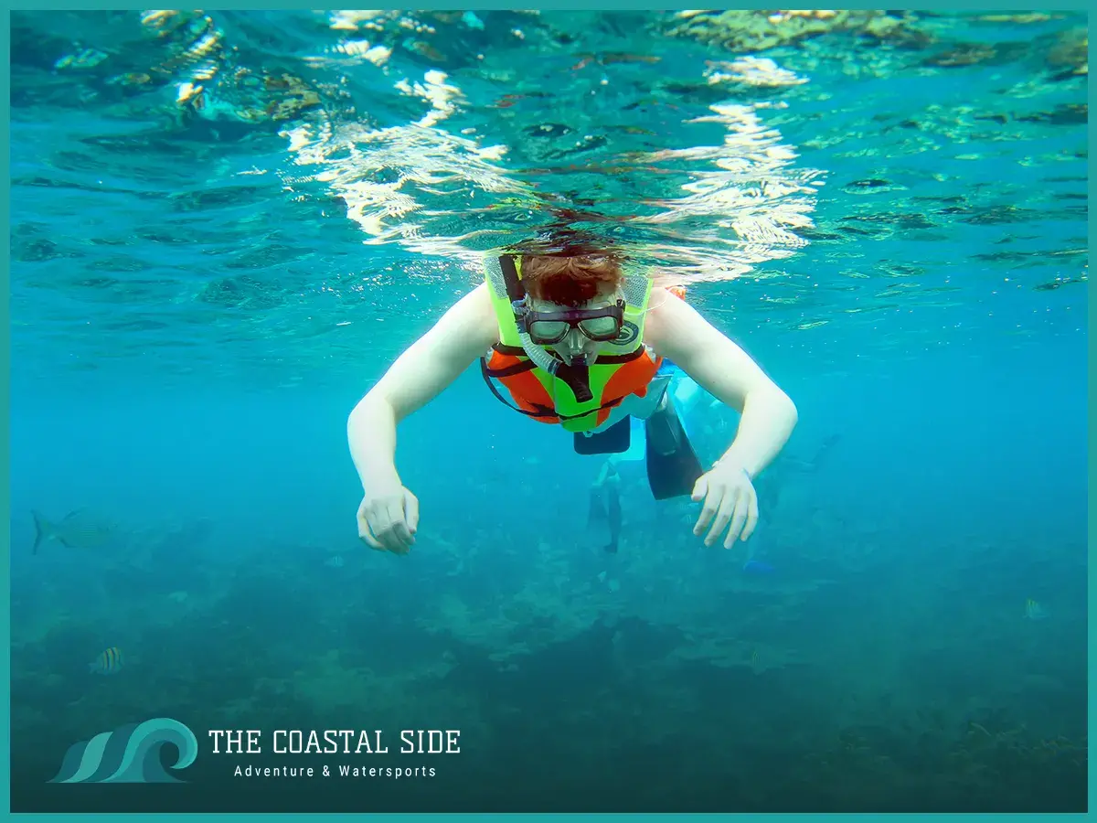 A child learning how to float on the surface of the water while snorkeling