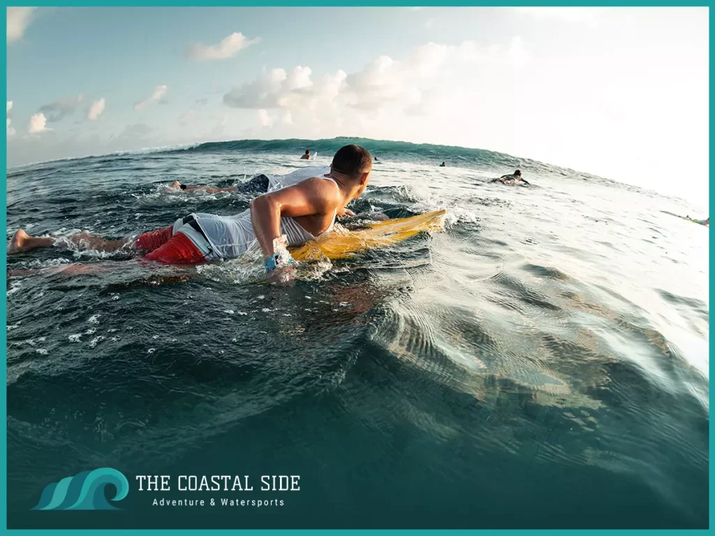 Man paddling out to past the breaks on his surf board