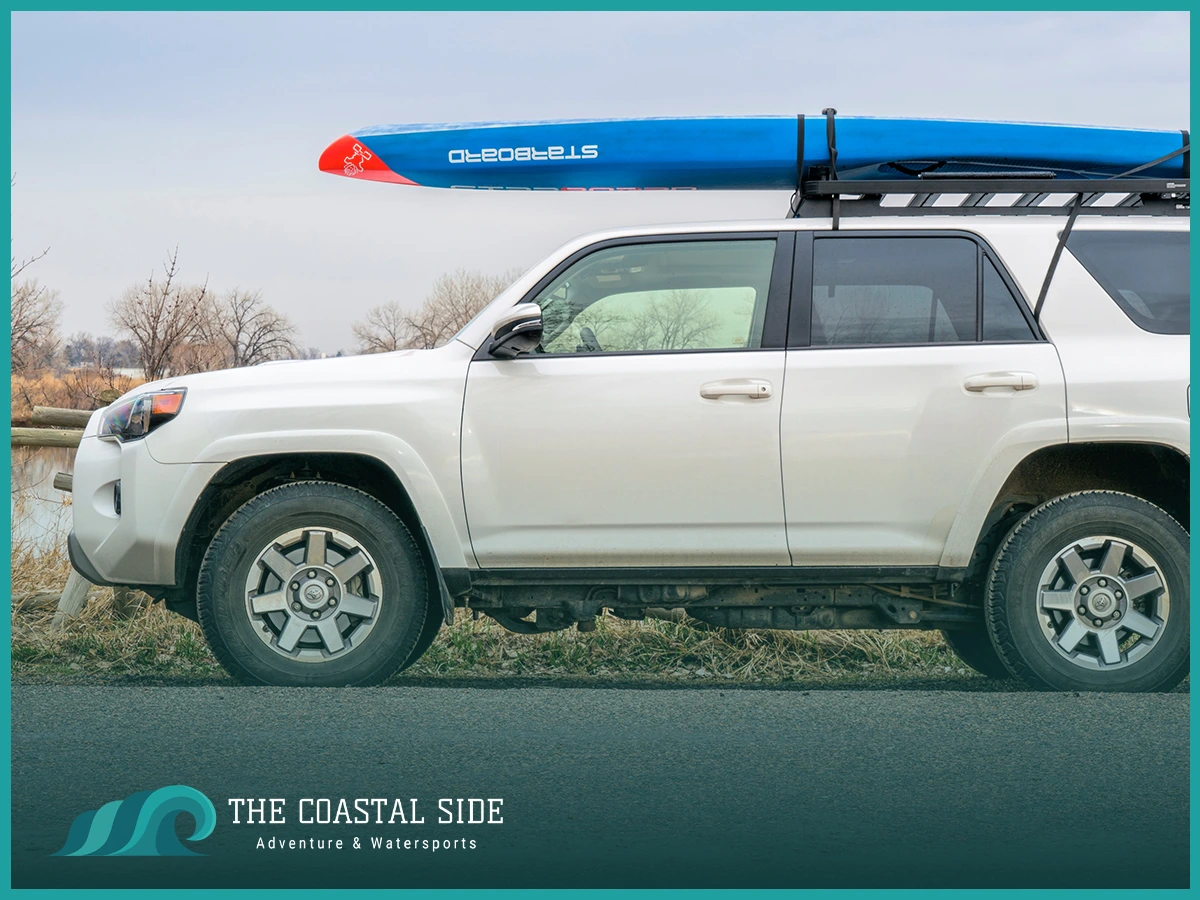 A white four runner carrying a paddle board on the roof