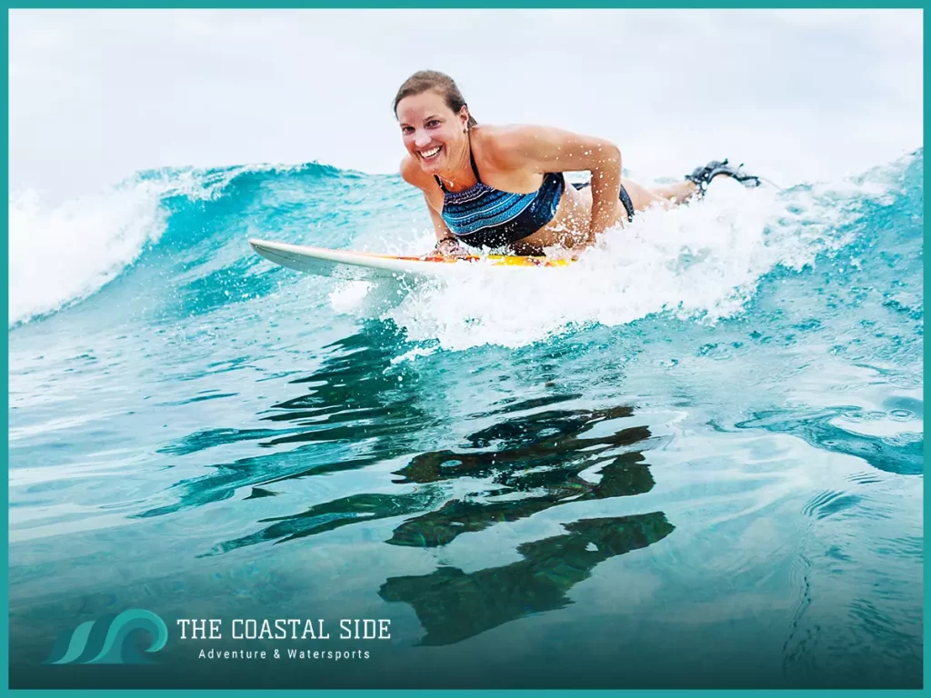 Woman getting ready to pop up on her surfboard