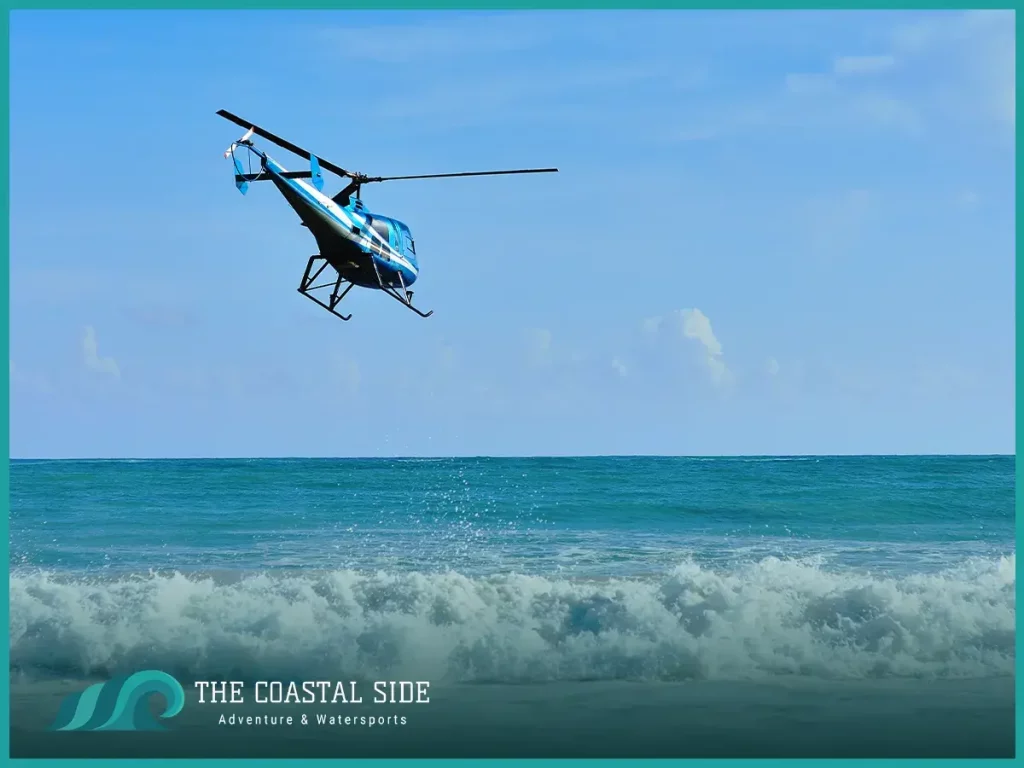 Helicopter over an ocean break getting ready to drop off a surfer