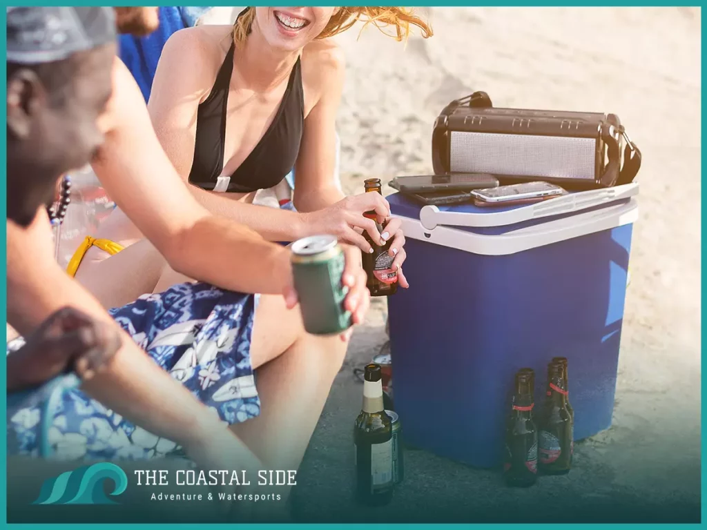 Friends with a beach cooler with ice cold drinks
