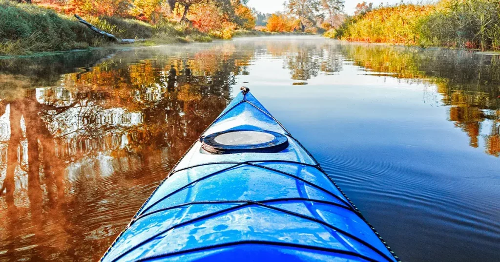 how to winterize your kayak in fall lake reflection with autumn leaves
