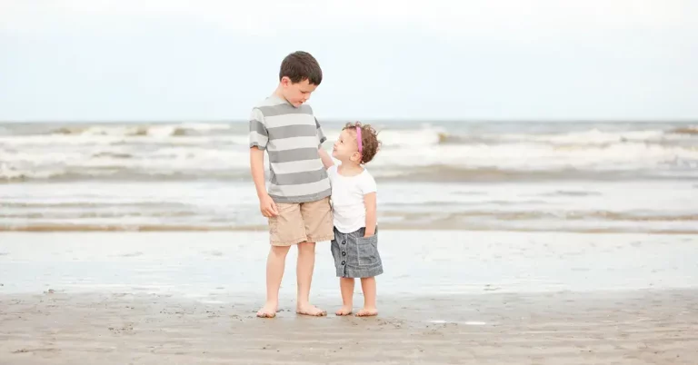 A boy and girl standing on texas white sand beaches