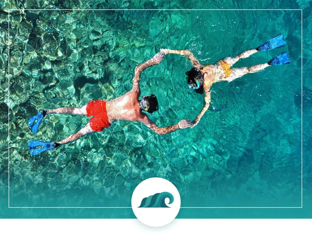 A young couple holding hands while snorkeling