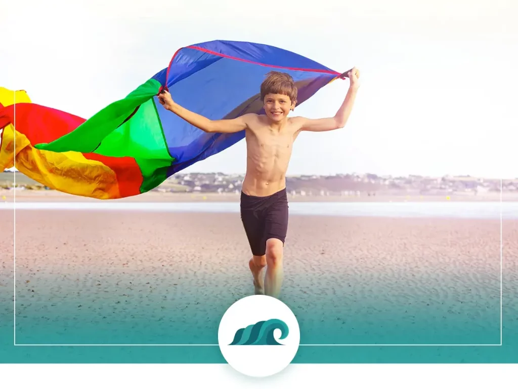 A boy playing parachute games at the beach