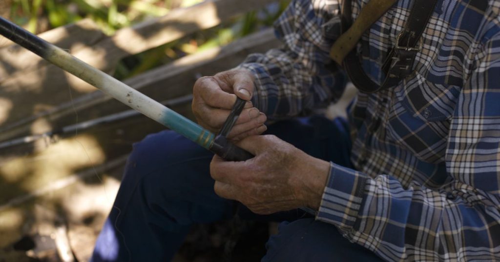 Old man fixing a fishing rod