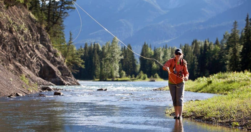 Girl fly fishing in lake